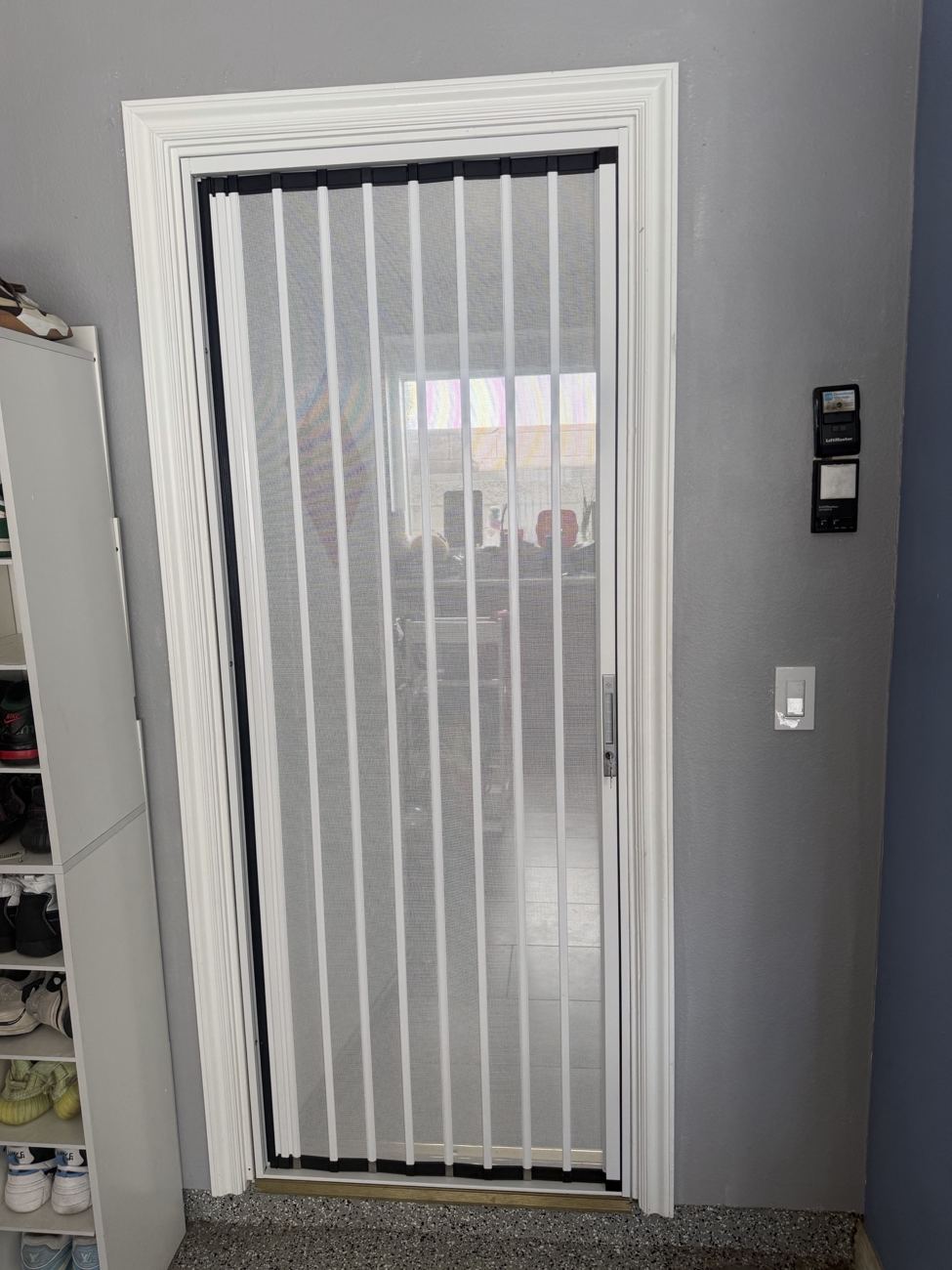 White folding screen on an interior garage door with a lock
