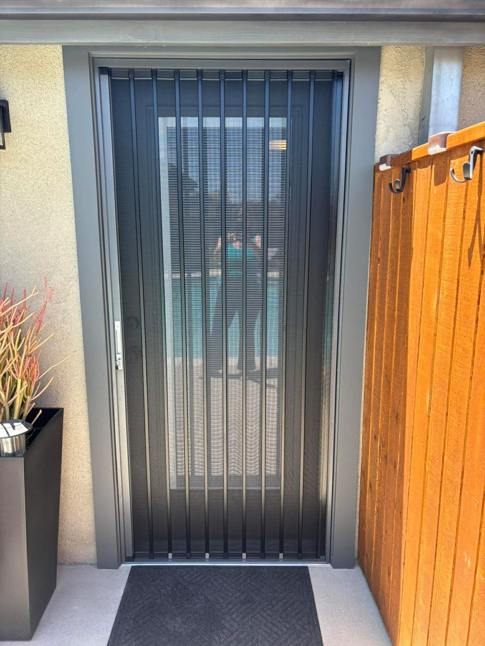 Dark bronze folding screen on a single door with a gray surround